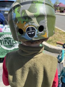 Child wearing a bike helmet with a sticker that says "I love my brain!"